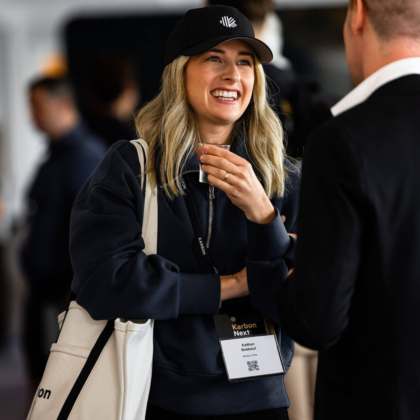A Karbon Next attendee smiling and talking with another person at a networking event
