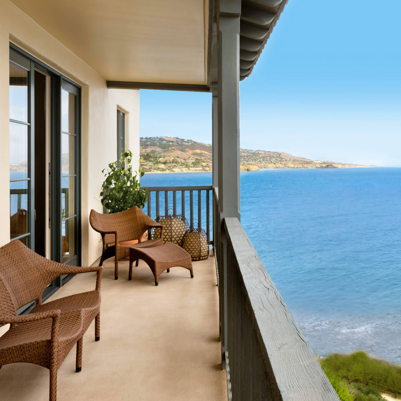 A private balcony with wicker chairs at Terranea Resort, overlooking the ocean and Palos Verdes coastline